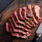 Corned beef cooked and sliced on a cutting board, irish recipe idea for St Patricks day