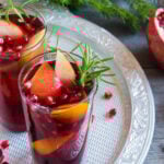 Fall and winter sangria with oranges, apples, pomegranate seeds, rosemary and spices - homemade festive drink for Thanksgiving