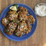 Sweet corn elotes latkes on a blue plate